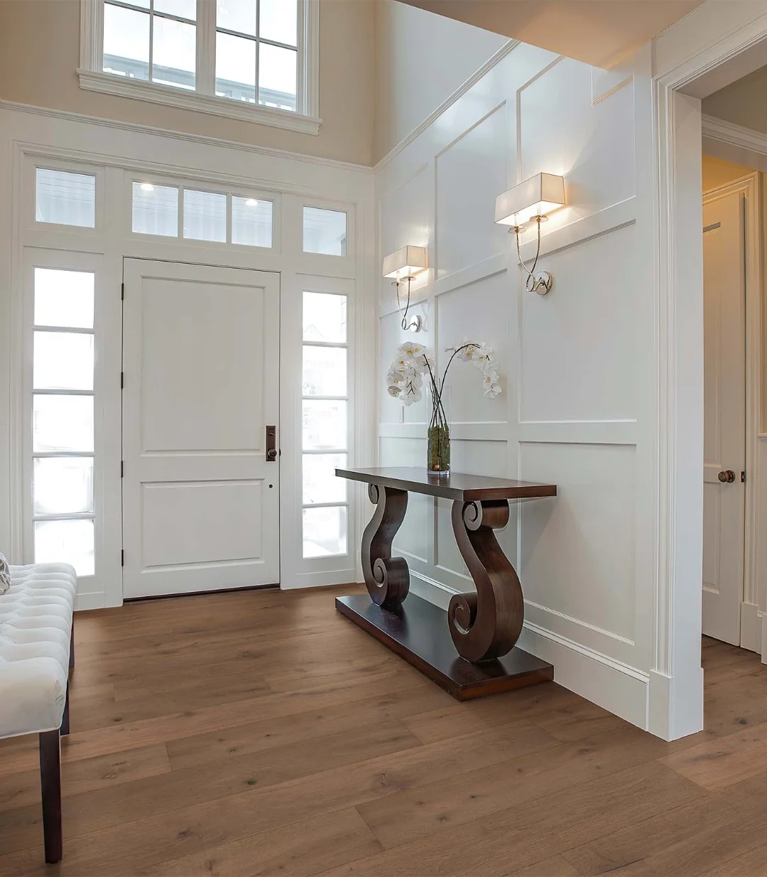 Entryway showcasing wide-plank hardwood flooring with warm oak tones and classic interior styling